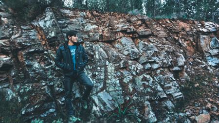 Man Wearing Jacket Standing in Stone Ledge