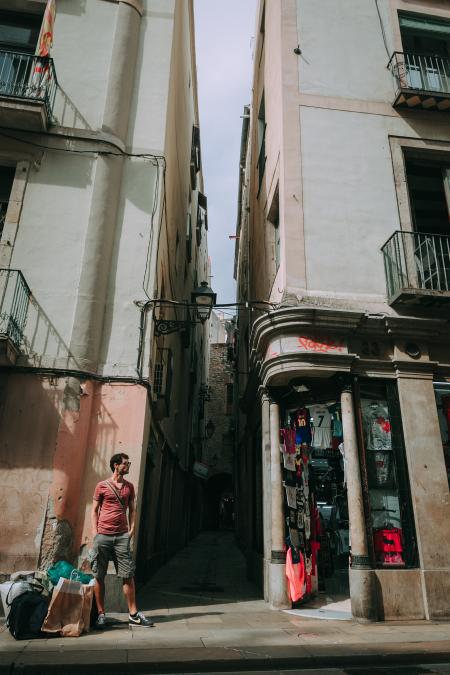 Man Wearing Red Shirt Standing Near a Concrete Structure