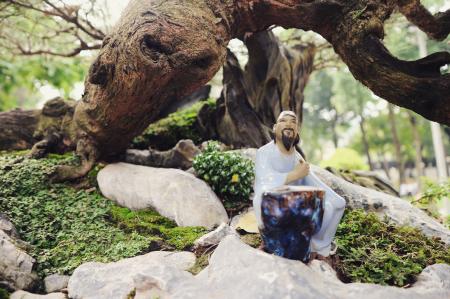 Man Wearing White Shirt Sitting on Gray Rock