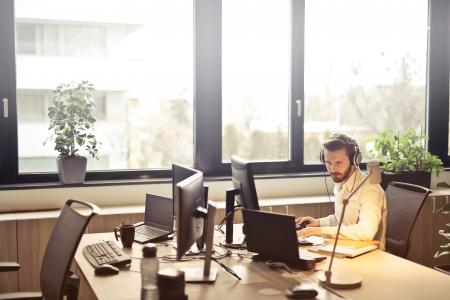 Man With Headphones Facing Computer Monitor