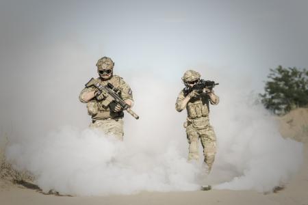 Men Holding Rifle While Walking Through Smoke Grenade