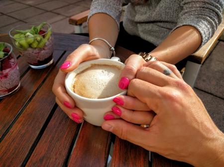 Midsection of Woman Holding Coffee Cup on Table