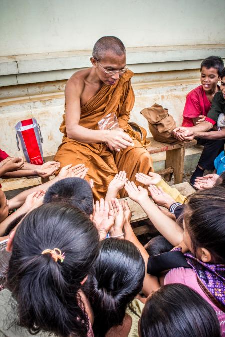 Monk Handing Towards Kids