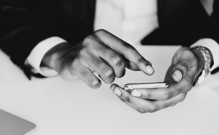 Monochrome Photography of a Person Using Mobile Phone