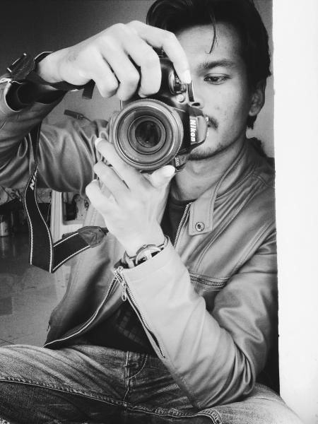 Monochrome Photography of Man Holding Black Nikon Camera