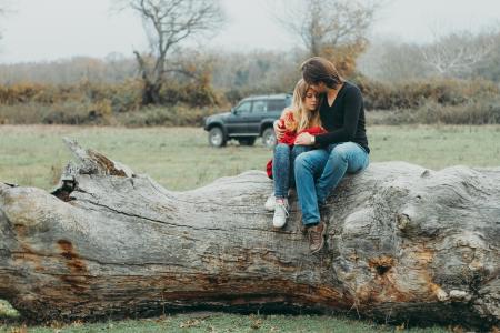 Mother and Daughter Sitting on Tree Log