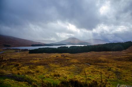 Mountain Beside Body of Water Under White Clouds