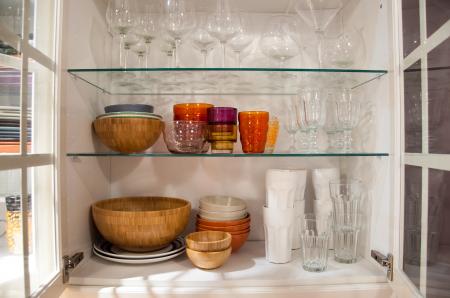 Opened cupboard with kitchenware inside