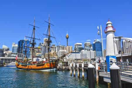 Orange Galleon Ship on Body of Water Beside City Buildings