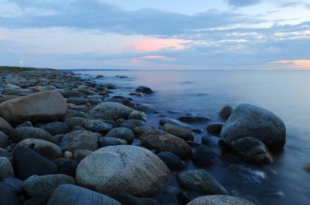 Pebbles on Beach Against Sky during Sunset