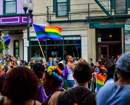 People Gathered Near Building Holding Flag at Daytime