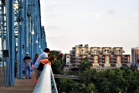 People Looking Down A Bridge