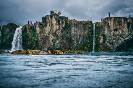 People Near Cliff Under Cloudy Sky