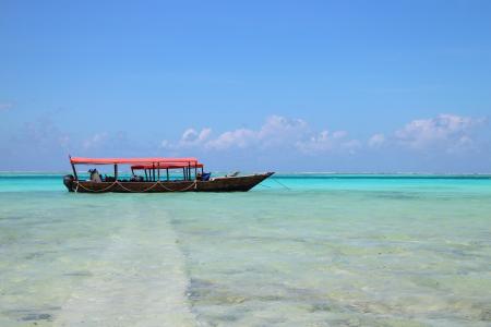 People on Black Boat Under Blue Sky at Daytime