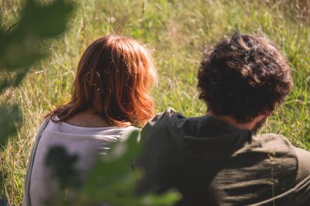 People Photography of Man and Woman Sitting on Green Grass Field