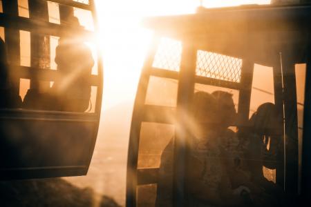 People Riding Cable Carts during Sunset