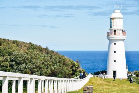 People Standing in Front of White Concrete Lighthouse during Daytime