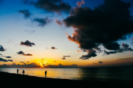 People Standing on Seashore during Sunset