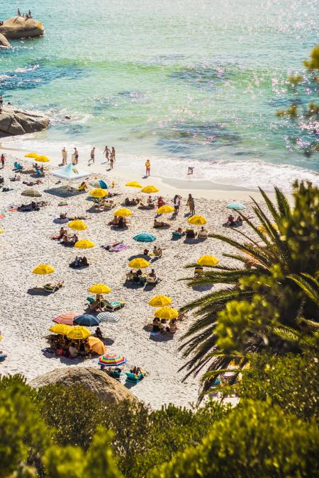 People Sunbathing and Swimming on Seashore