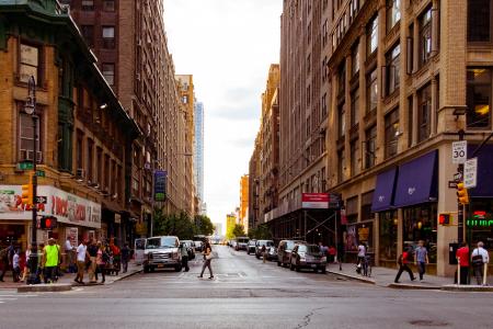 People Walking on Alley Surrounded by High Rise Buildings