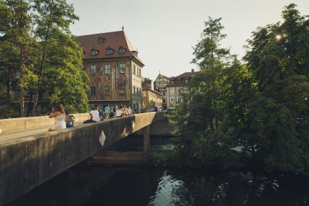 People Walking on Bridge Near the Town during Daytime