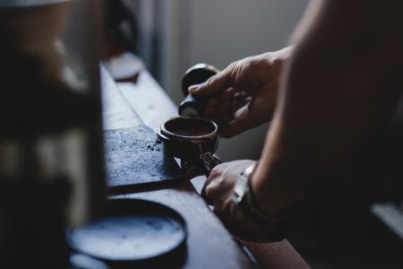 Person Holding Black Ornament While Shaping Metal Component