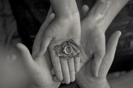 Person Holding Leaf and Ring in Grayscale