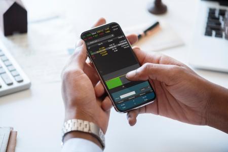 Person Holding Smartphone in Front of Desk