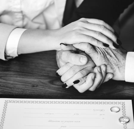 Person Holding Their Hands on Brown Wooden Table