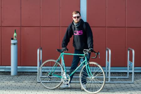 Person In Black Hoodie Holding Green Bike