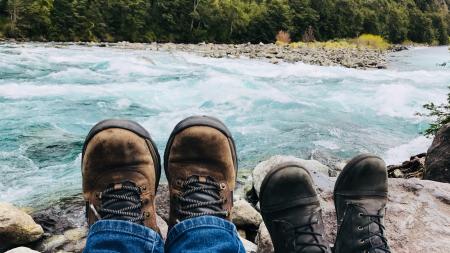 Person in Brown Boots Near Body of Water at Daytime