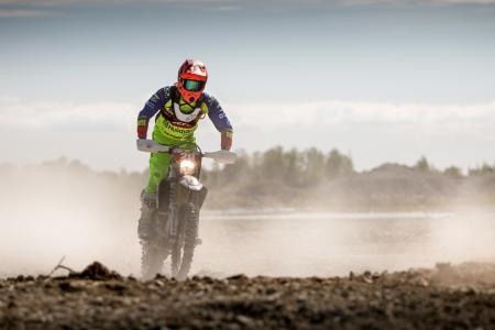 Person In Green Motocross Gear Riding A Dirt Bike