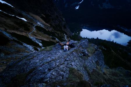 Person in White on Cliff Near Body of Water