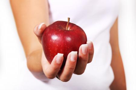 Person in White Shirt Holding Red Apple