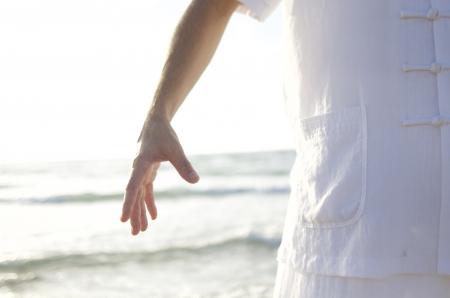 Person in White Shirt Standing on Seashore during Daytime