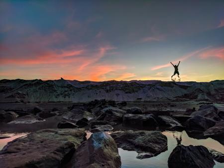 Person Jumping on Mountain Photo