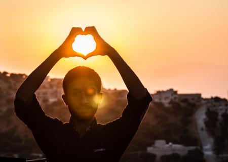 Person Making Heart Shape With His Hand During Sunset