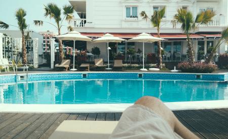 Person Relaxing Near a Swimming Pool