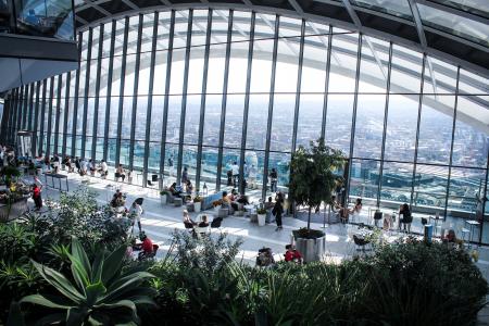 Person Sitting Inside Gray Framed Clear Glass Wall Building