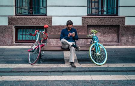 Person Sitting on Bench Between Two Road Bikes