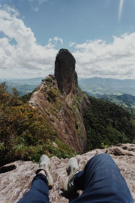 Person Sitting on Gray Rock Formation