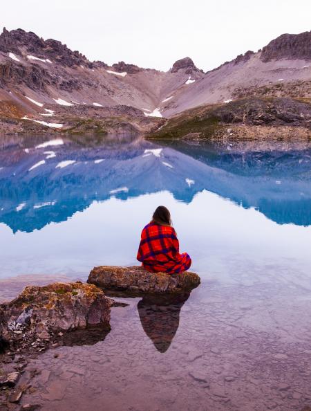 Person Sitting On Rock By The Lake