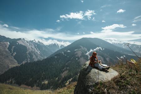 Person Sitting on Rock Near Cliff