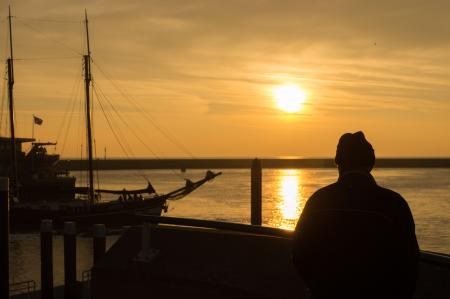 Person Standing on Dock during Sunset