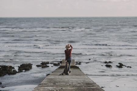 Person Standing on Dock Holding Textile