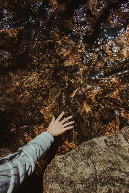 Person Touching Brown Stone