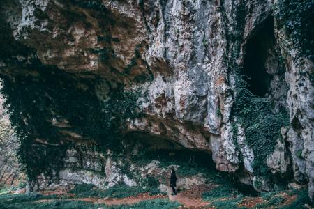 Person Under Black and Gray Cliff