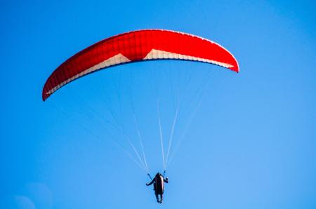 Person Using Red Parachute on Mid Air