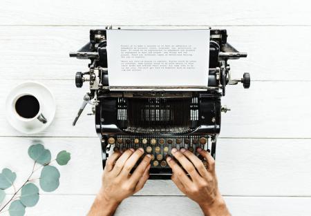 Person Using Typewriter on White Surfac