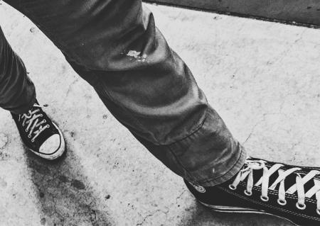 Person Walking Wearing Black Shoes in Grayscale Photography